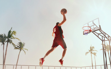 Streetball. Basketball player in action on sunset.