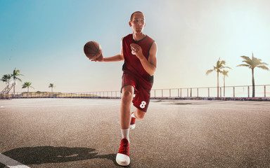 Streetball. Basketball player in action on sunset.