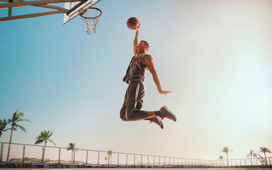 Streetball. Basketball player in action on sunset.