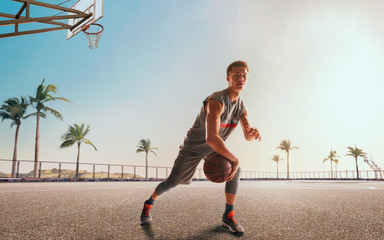 Streetball. Basketball player in action on sunset. © Artur Didyk