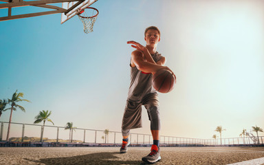 Streetball. Basketball player in action on sunset.