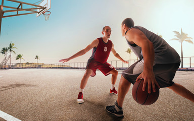 Streetball. Basketball player in action on sunset.