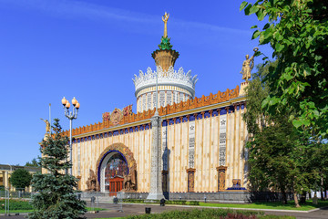 Fototapeta na wymiar Facade of pavilion Ukrainian SSR on Exhibition of Achievements of National Economy (VDNH) in Moscow against green trees and blue sky on a sunny summer morning