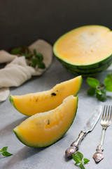 Two pieces of watermelon, a kitchen towel and a knife