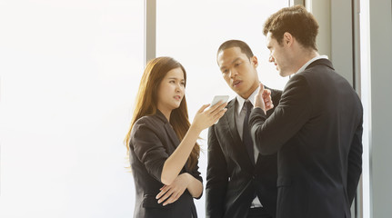 Successful Multi-ethnic colleagues or coworkers develop advertising campaign, discuss ideas and share opinions during work process, read documents and have smartphone conversation,being at office