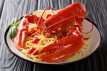 whole boiled lobster with Italian spaghetti close-up on a platter. Delicacy menu. horizontal