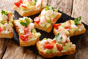 Toasted sandwiches with lobster, avocado, tomatoes and cream cheese close-up on the table. horizontal, rustic