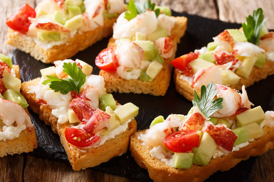 Beautiful food background: sandwiches with lobster, avocado, tomatoes and cream cheese macro. horizontal