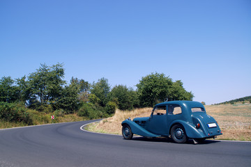  old blue car on the road
