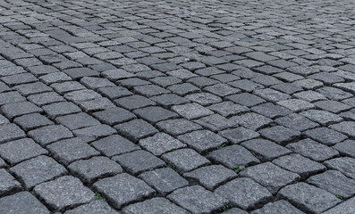 Old road paved with stone. The texture is clearly visible.