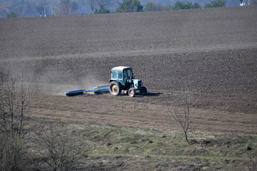 The tractor prepares the soil for sowing agricultural crops
