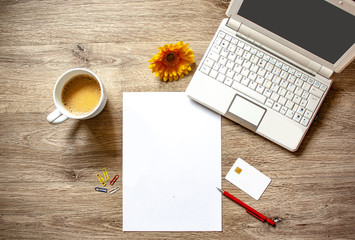 Flat lay with a cup of coffee,white paper,notebook,tablet and white creditcard