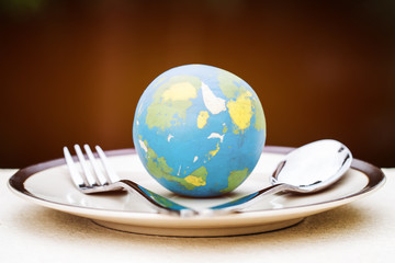 Globe model placed on plate with fork spoon for serve menu in famous hotels. International cuisine...