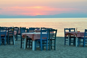 Greek tavena on a beach on a beautiful sunset