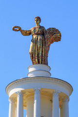Obraz premium Figure of woman of collective farmer with sheaf and wreath on a roof of pavilion Republic Of Belarus on Exhibition of Achievements of National Economy (VDNH) in Moscow
