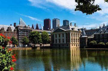 Skyline of The Hague with the modern office buildings behind the Mauritshuis museum and the Binnenhof parliament building next to Hofvijver lake. 
