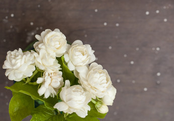 White jasmine flowers in a glass.Beautiful jasmine flower in the pot on the wooden table background.Top view on blur copy space background.