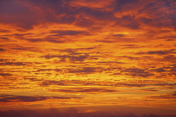 Sunset sky background. Dramatic sunset sky with evening sky clouds lit by bright sunlight - natural city sunset sky landscape view.