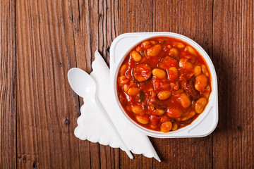 Baked beans in tomato sauce served in plastic cups.