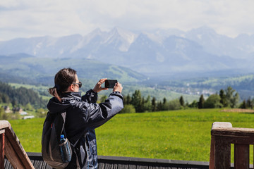 Fototapeta na wymiar Tourist in the mountains photographing beautiful views.