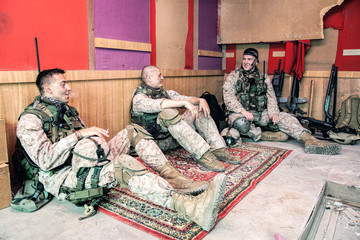 United States marines in camouflage uniform and ammunition sitting on floor at combat outpost or...