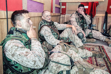 United States marines in camouflage uniform and ammunition sitting on floor at combat outpost or...