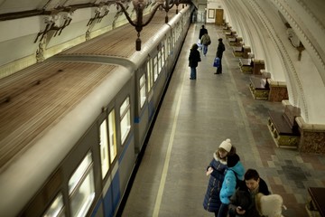 Train Moving at Subway Station with Passengers on Platform