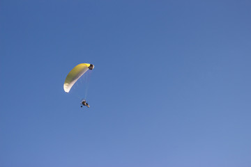Silhouette of a paraglider against a clear blue sky. Extreme sport. Place for copy-paste