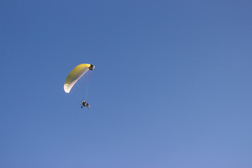 Silhouette of a paraglider against a clear blue sky. Extreme sport. Place for copy-paste