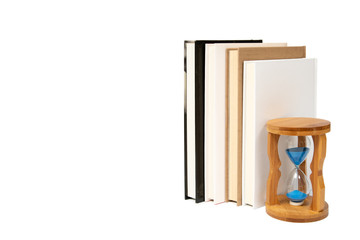 Hourglass and books isolated on white background.