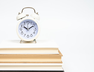Alarm clock and books isolated on white background.