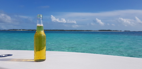 Fresh bottle of beer with the Caribbean Sea as background
