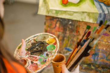 Close up of paintbrush and  palette in little kid hands