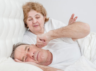 Fototapeta na wymiar elderly couple is quarreling on the bed