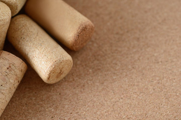 Pile of assorted used wine corks on brown natural craft cork background. Close up top view. Free copy space.