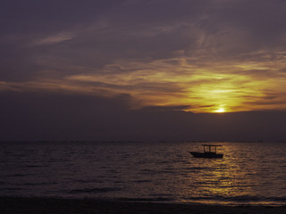 Boat floating in the sea during sunset.