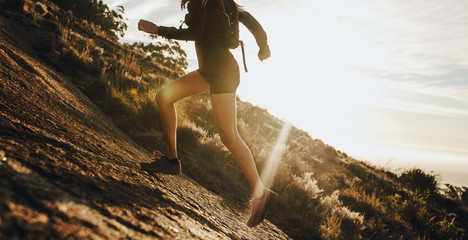 Woman running up a rocky mountain slope