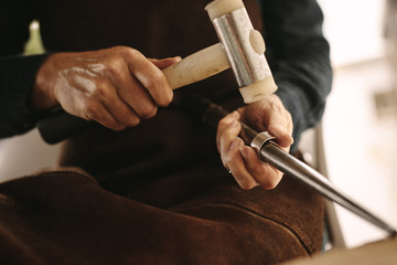 Jeweler working with the hammer on silver ring