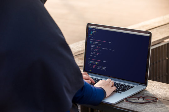 Hijab woman is working using laptop doing coding and programming for web development and web design concept at outdoor