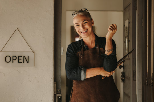 Smiling jewelry maker at workshop entrance