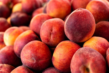 A heap of ripe red peaches at market. Background.
