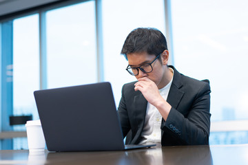 a businessman is working seriously with his laptop computer.