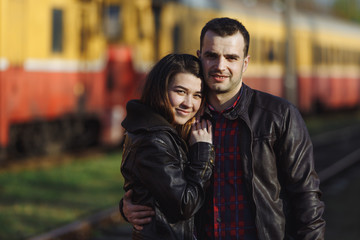 Young couple hugging on the background of a passing train.