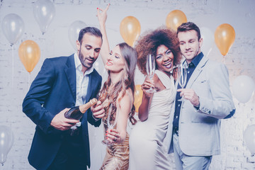 Leute feiern Party im Club mit Sekt und stoßen auf das neue Jahr an
