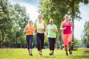 Familie mit Personal Fitness Trainer beim Laufen