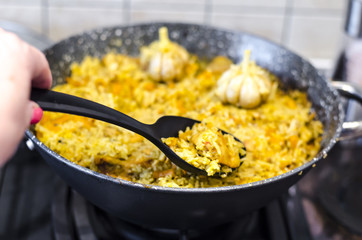 Pilaf with carrots and meat in frying pan