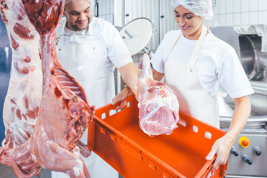 Team von Fleischer oder Schlachter zerlegt Fleisch im Schlachthof