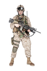 Full length studio shoot of marine infantry, commando soldier in full protective ammunition, standing with service rifle equipped grenade launcher and looking at camera, isolated on white background