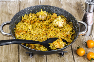 Pilaf with carrots and meat in frying pan