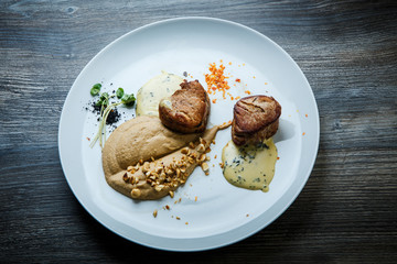 top view on two tasty pieces of grilled meat with puree and sauce